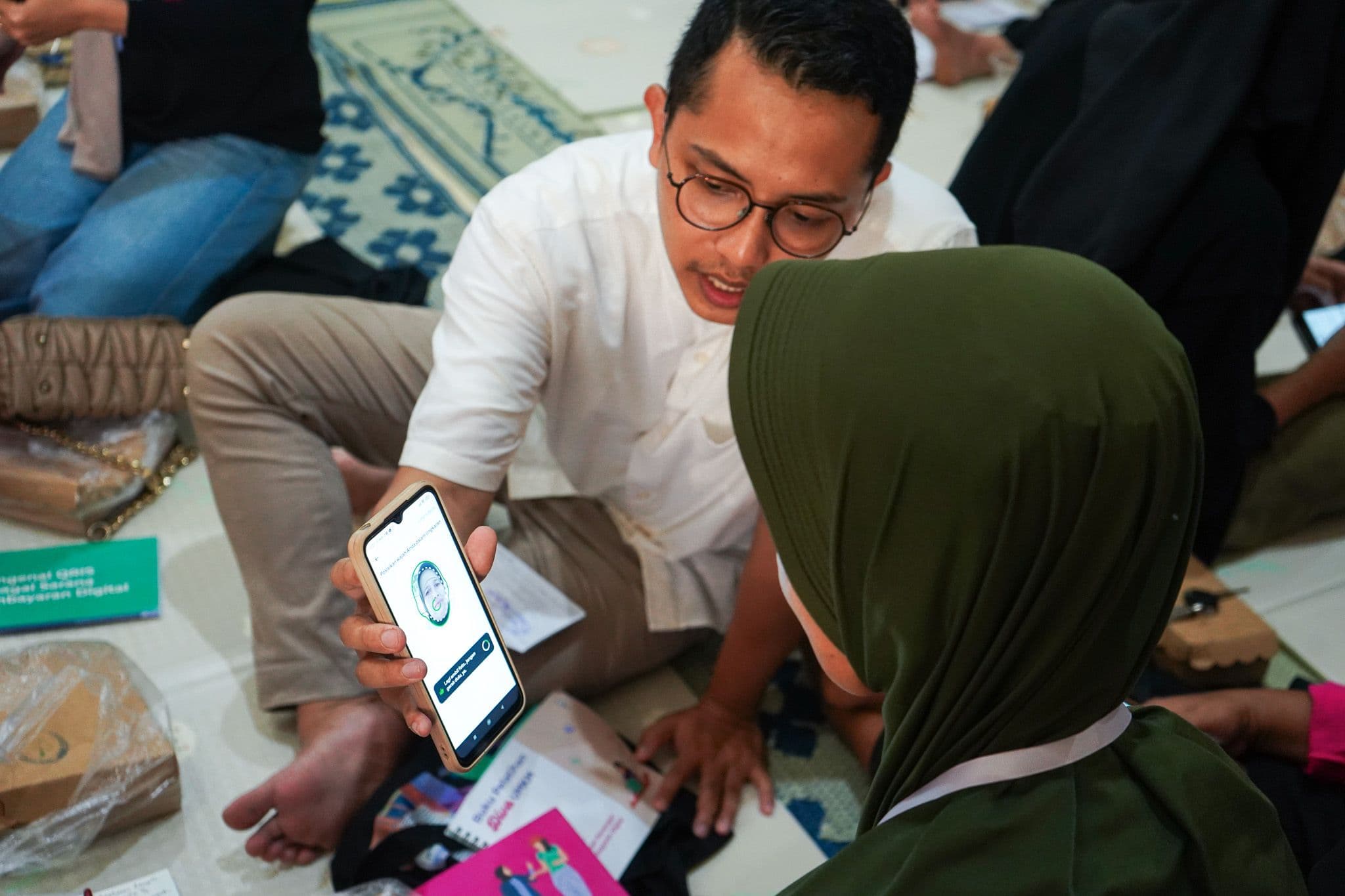 Foto trainer program Diva UMKM sedang menunjukkan cara memasarkan produk secara digital kepada salah satu peserta program.